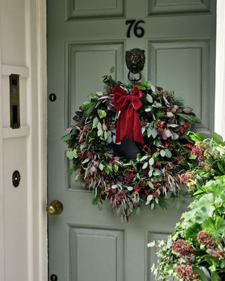 Christmas wreath on green door with red bow