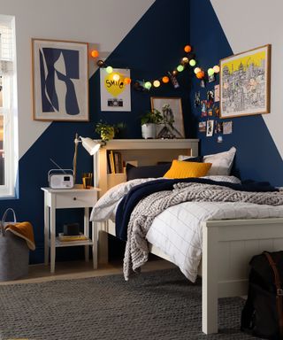 Navy blue and yellow boys bedroom with built-in shelf in bed by Furniture and Choice