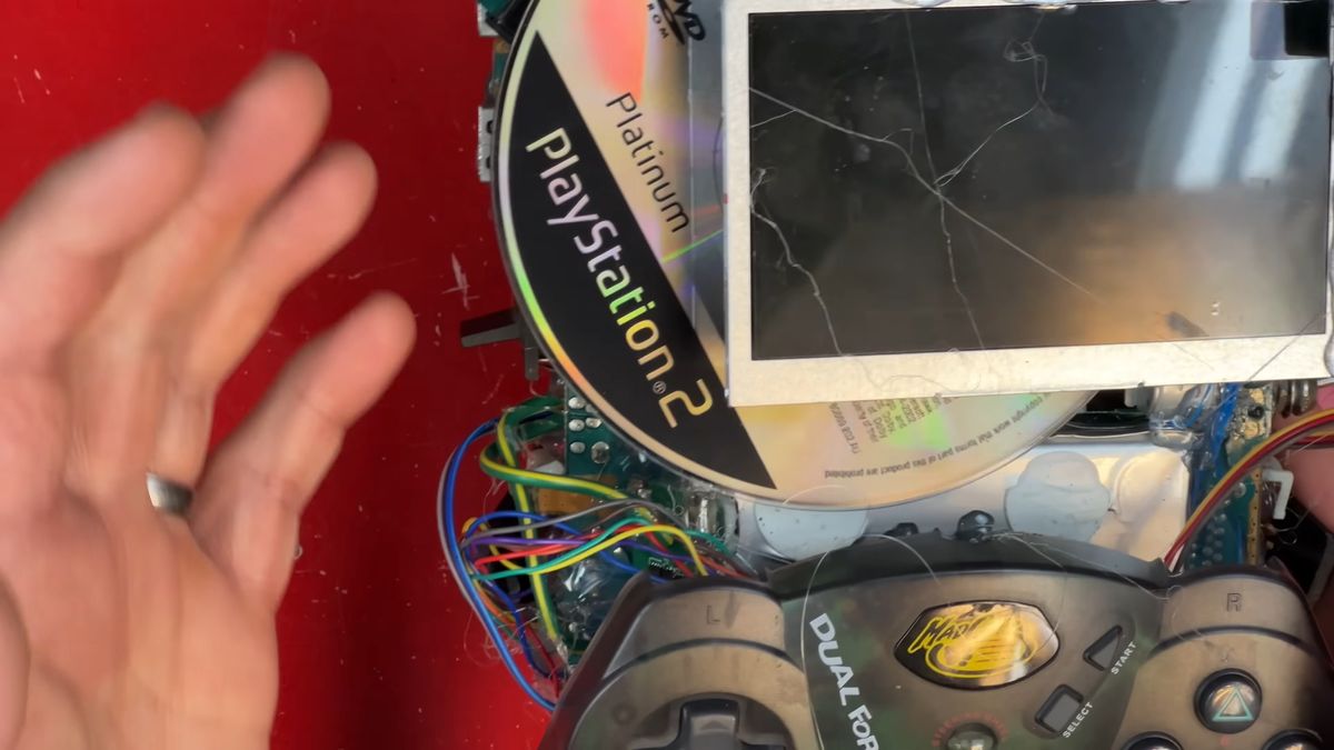 Close up of DIY PS2 handheld with disc under LCD screen.