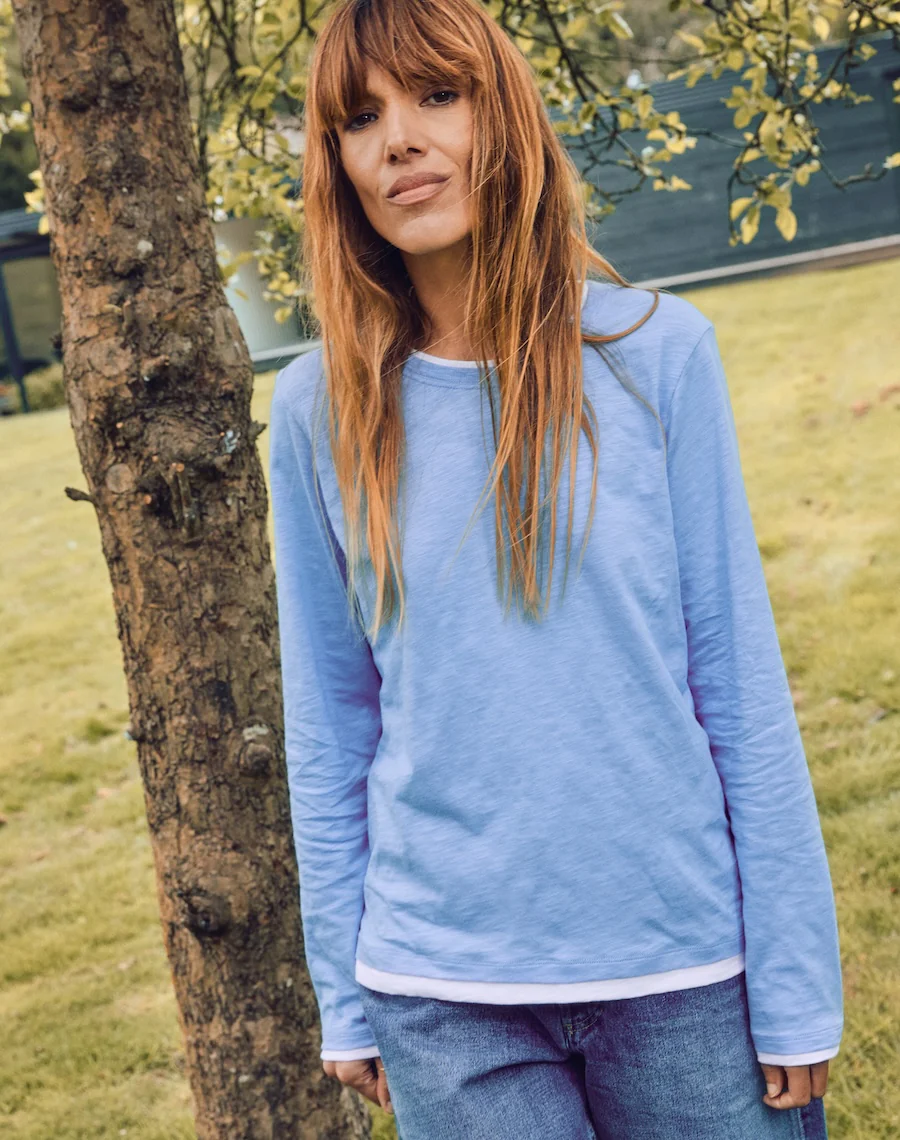 A model wearing a Navygrey blue long sleeve t-shirt with layered neckline and cuff detail.
