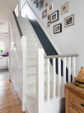 Hallway staircase with white stairs and blue walls