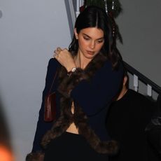 Kendall jenner wears a fur-trimmed sweater and leggings.
