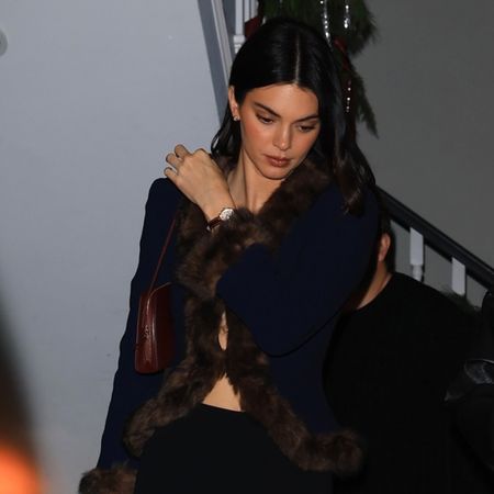 Kendall jenner wears a fur-trimmed sweater and leggings.