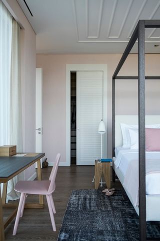 pale pink bedroom with black four poster bed