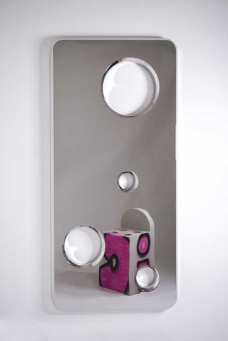 Rectangle mirror with holes design, reflecting an image of a pink street art chair, white background