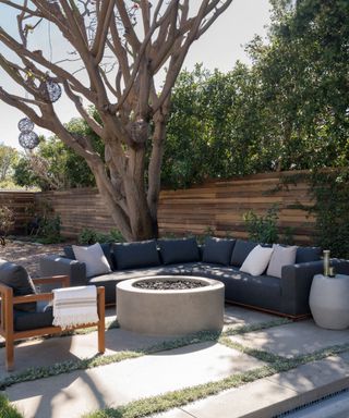 outdoor living room with a corner sofa and firepit