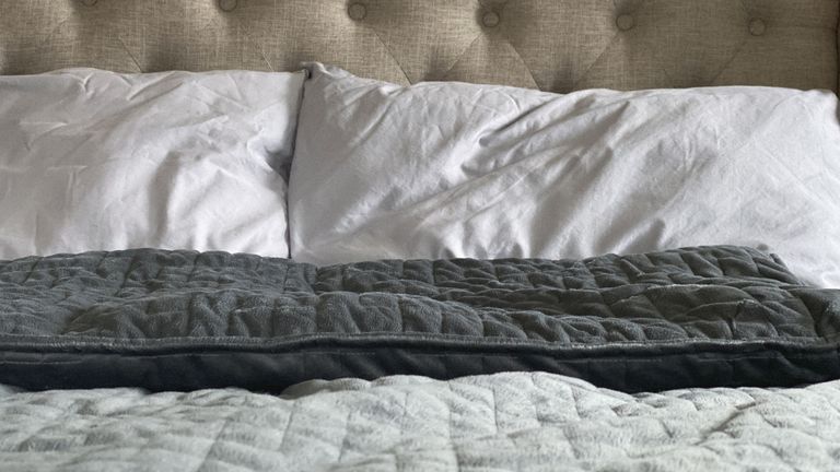 How heavy should a weighted blanket be: Image shows weighted blanket on bed