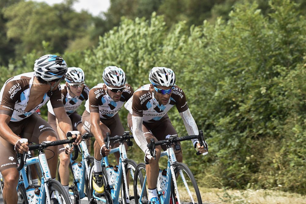 Jean-Christophe Peraud, injured after a fall on Friday, rides in the pack with his teammates of the AG2R La Mondiale, Romain Bardet and Christophe Riblon.