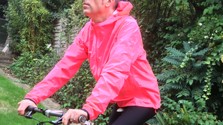 Male cyclist wearing the Rapha's Men's Commuter Lightweight Jacket which is one of the best commuter cycling jackets