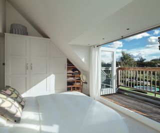 large bifold doors in dormer loft bedroom leading to a small balcony