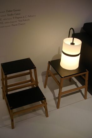 Two dark wood stools with black tops. A lamp sat on the right stool.