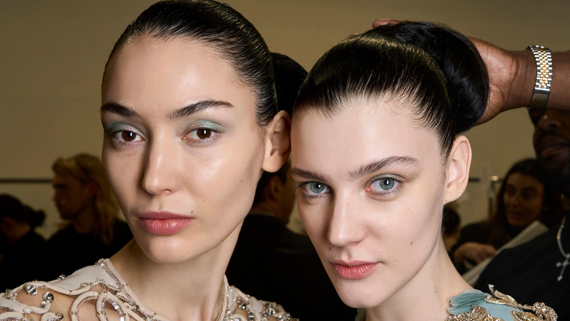 two models backstage with glowy skin