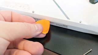 ROG Ally SSD upgrade: Use a plastic triangle pick to open the casing.