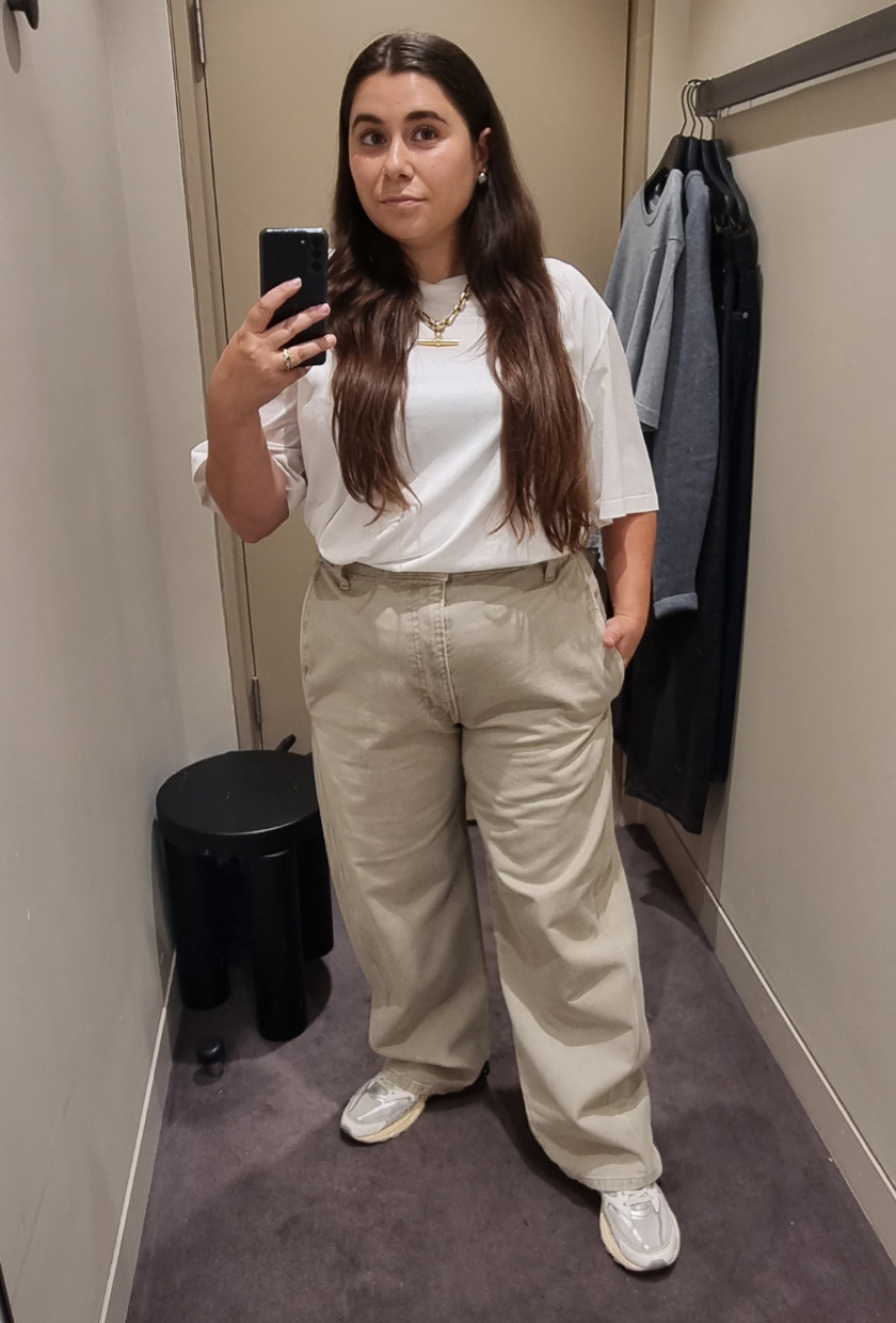 A woman wears a white t-shirt and beige wide-leg jeans