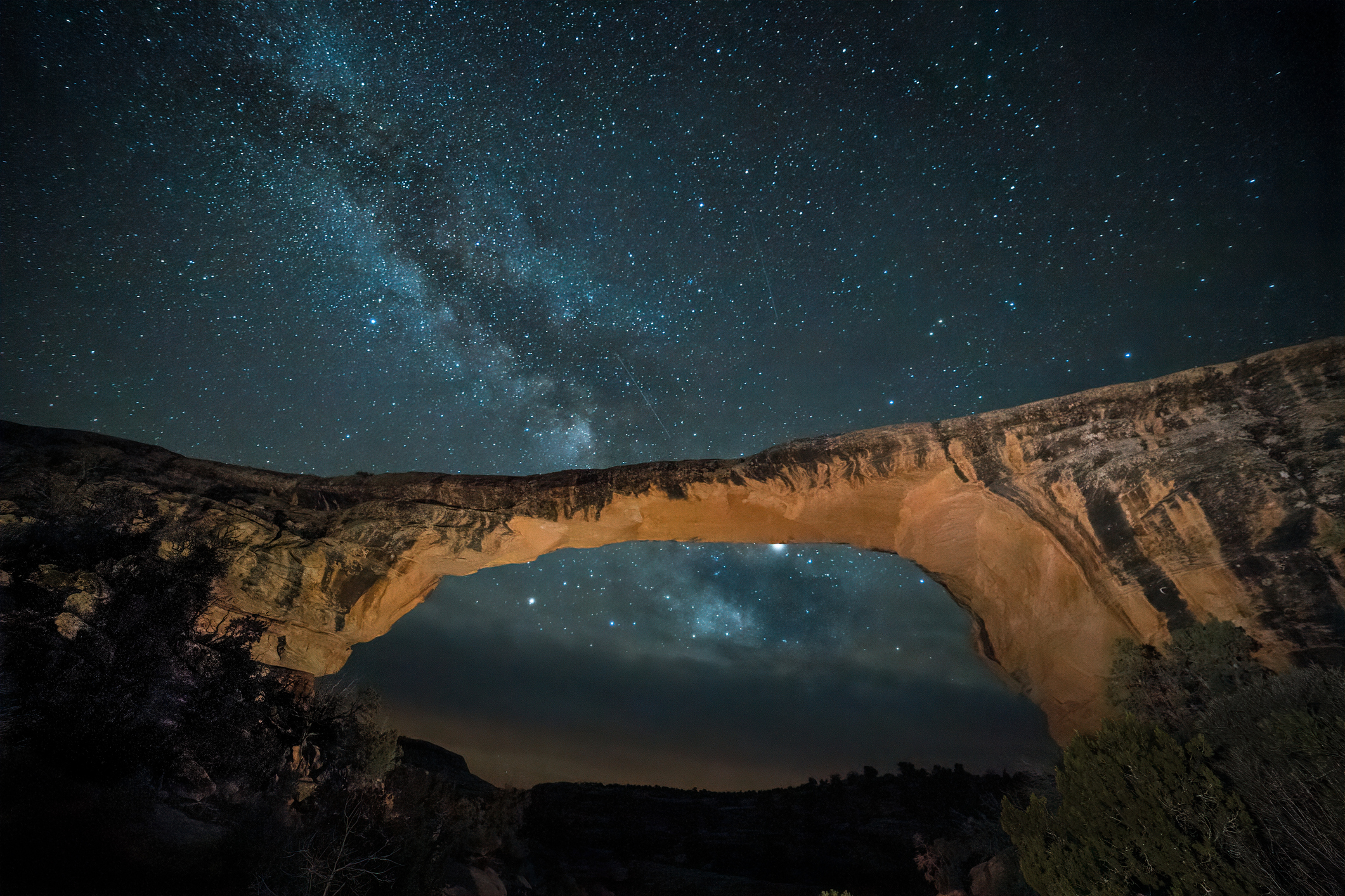 Large rocky bridge formation with the milky way in the background.