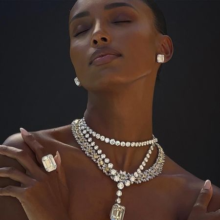 Model Jasmine Tookes wearing diamond earrings, bracelets, and rings during photoshoot.