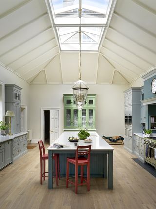 colorful kitchen with blue island red chairs and vaulted white ceiling