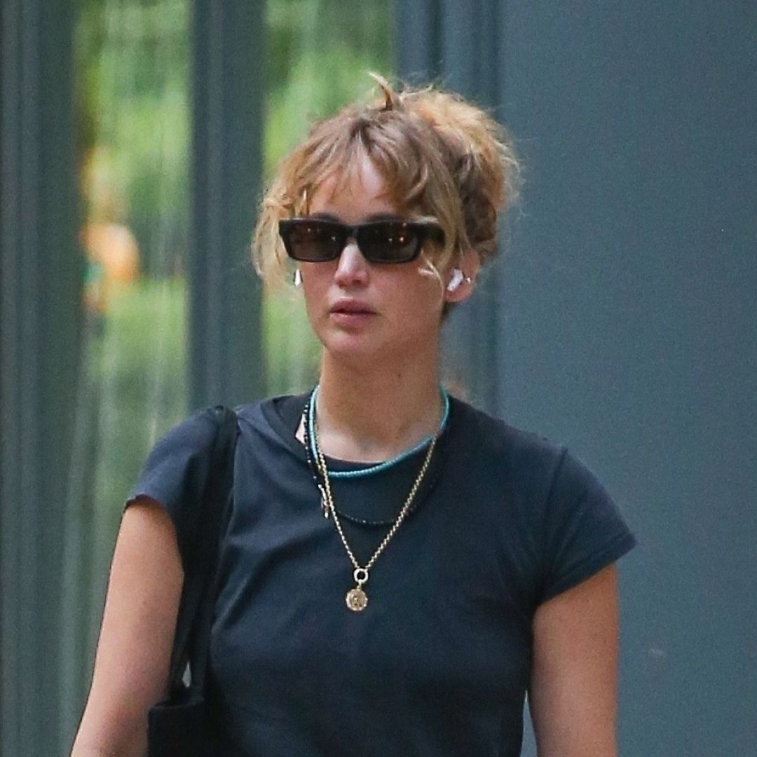 Jennifer Lawrence wearing baggy jeans with white Adidas Superstar sneakers