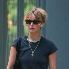 Jennifer Lawrence wearing baggy jeans with white Adidas Superstar sneakers