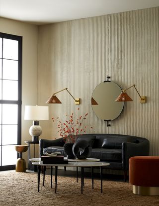 Neutral living room with black Arteriors sofa and paprika accents