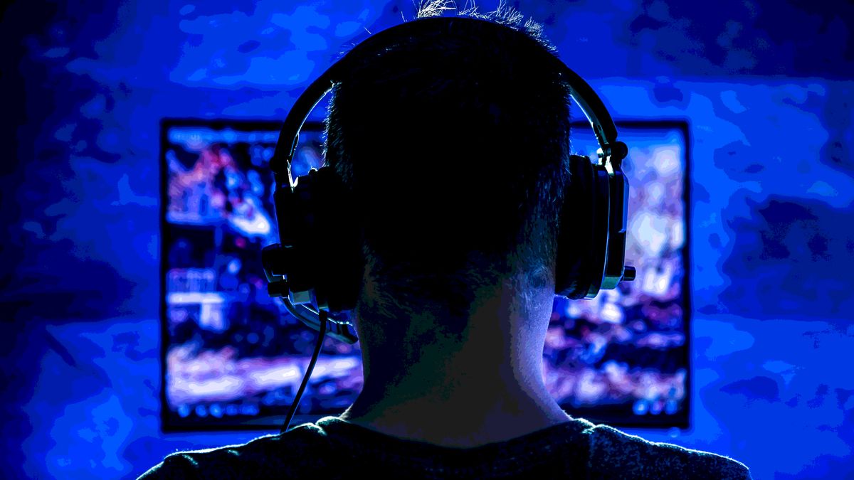 A man wearing headphones while playing a PC game.