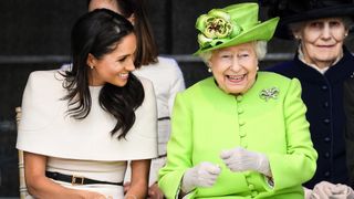 Queen Elizabeth II sits and laughs with Meghan, Duchess of Sussex during a ceremony to open the new Mersey Gateway Bridge