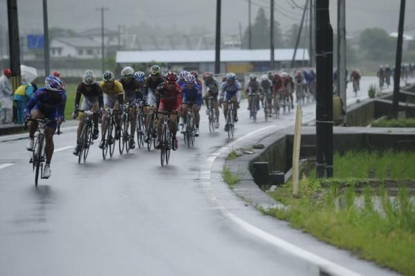 The peloton rides past a rice paddy