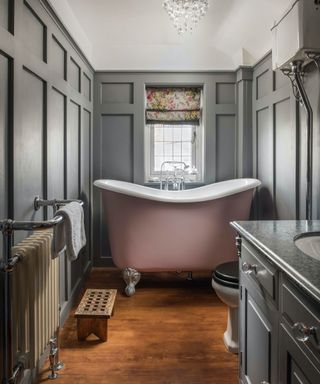 Tubby compact rolltop bath in grey paneled bathroom
