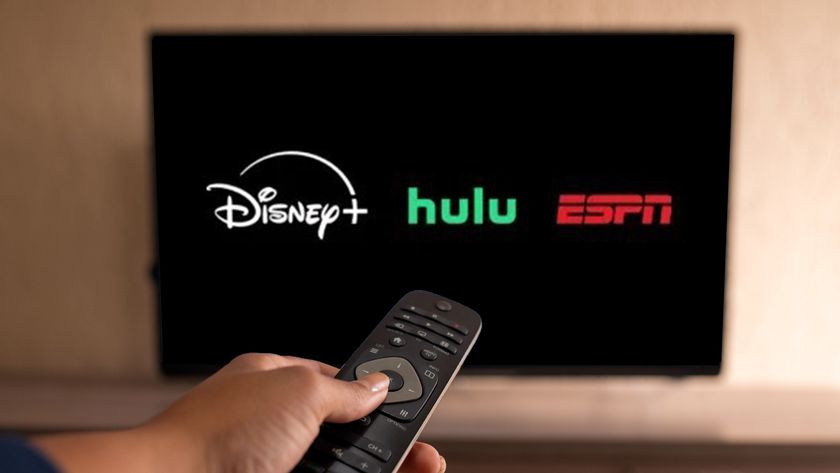 The Disney Plus, Hulu and ESPN logos superimposed on a TV screen.