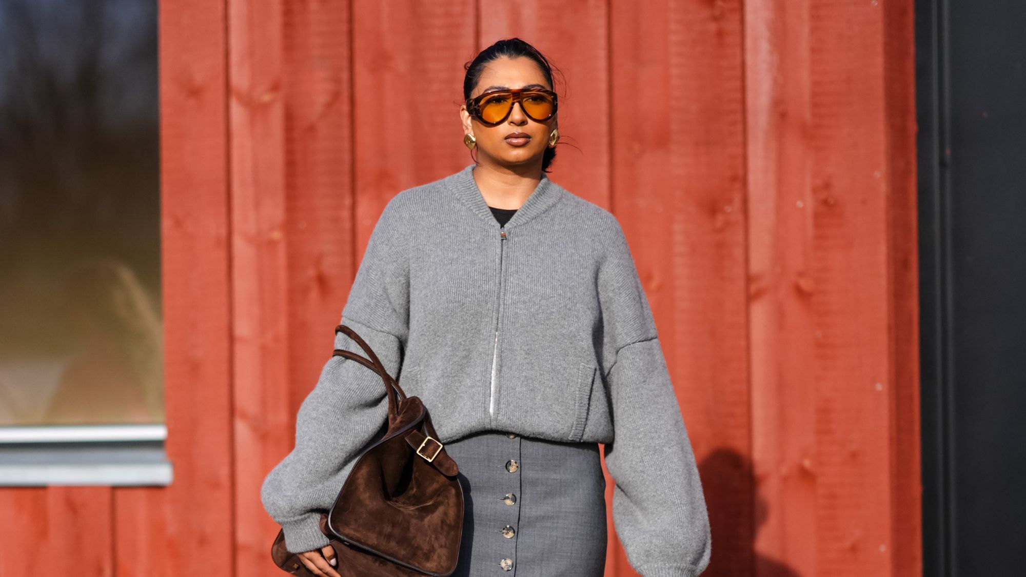 street style shot of woman with glowing skin wearing sunglasses