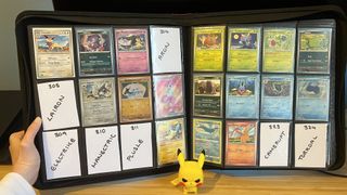 Hand holding Pokemon binder open with cards and placeholders in sleeves