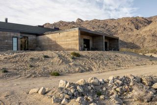 morning dove, a new house at twentynine palms by homestead modern, showing rammed earth walls, rough and contemporary volumes and windows out to desert landscape views