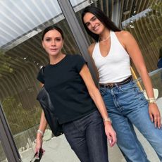 Victoria Beckham wears dark wash jeans with peep-toe shoes.