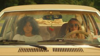 Chloe Fineman and Sam Morelos looking forward in a car in Summer of 69.