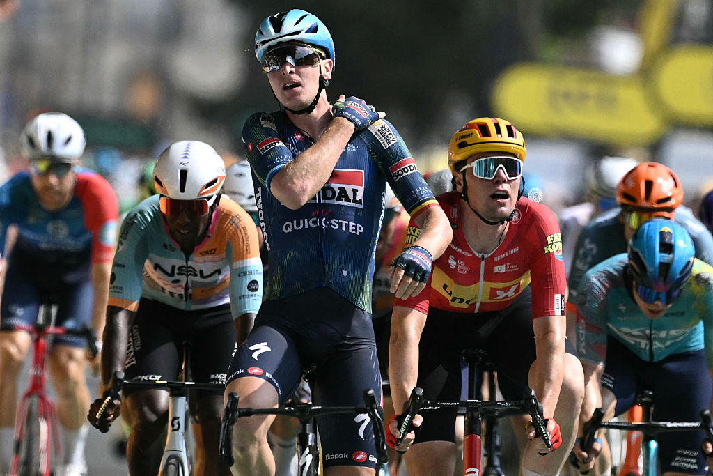 Soudal Quick-Step team's Belgian rider Tim Merlier rides across the finish line to win the 7th stage