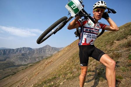 Eventual stage winner, Matthys Beukes (Squirt Lube) carries his bike to the summit of Wheeler Trail.