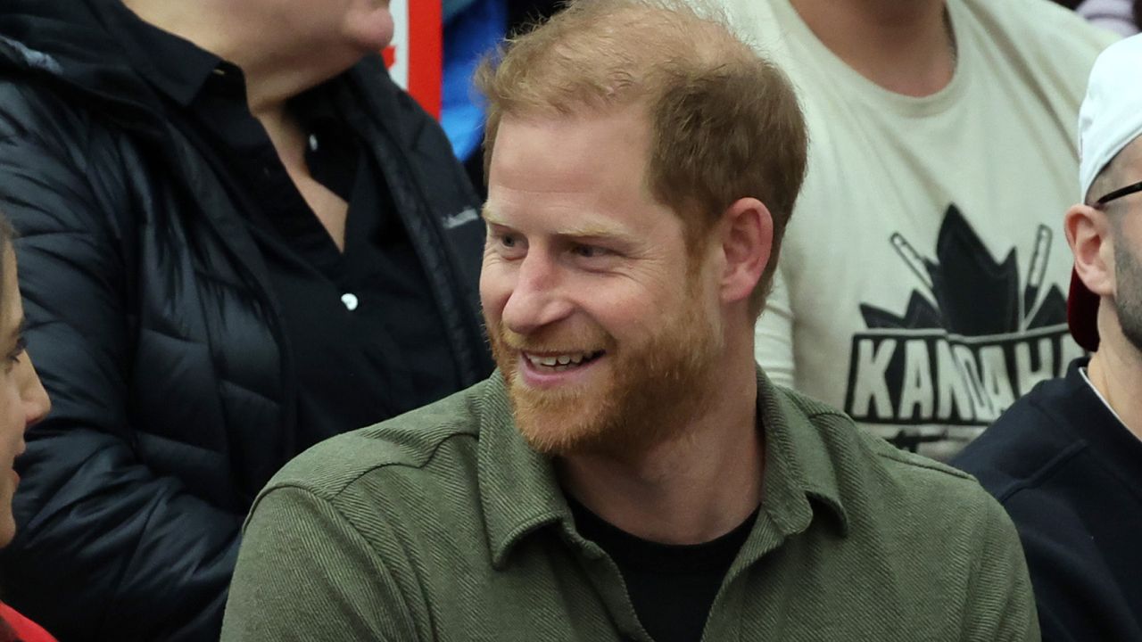 Prince Harry wears a khaki green shirt and smiles at the Invictus Games 2025 in Canada