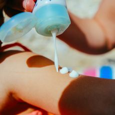 a person applying sunscreen on a beach