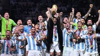Argentina's captain Lionel Messi (C) lifts the FIFA World Cup Trophy as he celebrate with teammates winning the Qatar 2022 World Cup final.