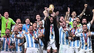 Argentina's captain Lionel Messi (C) lifts the FIFA World Cup Trophy as he celebrate with teammates winning the Qatar 2022 World Cup final.