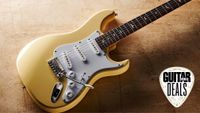 A PRS SE Silver Sky electric guitar lying on a distressed floor, with the Guitar World deals logo in the corner