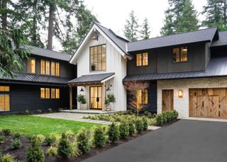 Double-duty front walkway ideas in front of a white and black panelled house surrounded by large trees.