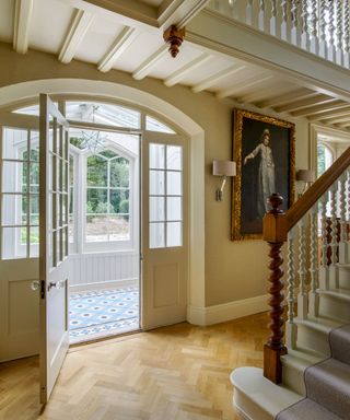 Ivory hallway with stairway and parquet floor