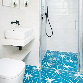 White bathroom with black hardware and turquoise tiles