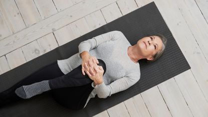 A woman stretching on a yoga mat as part of her mobility training