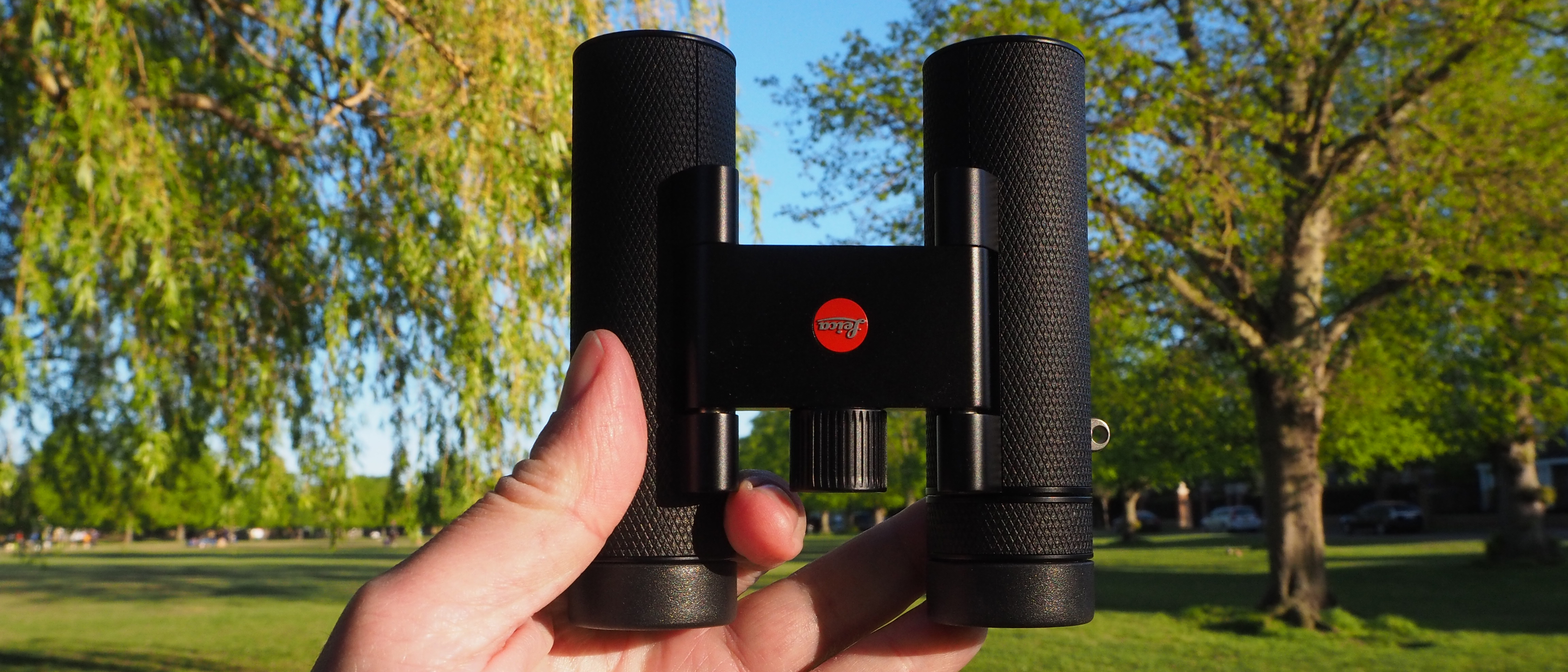 Leica Noctivid Compact 10x25 binoculars in a person's hand