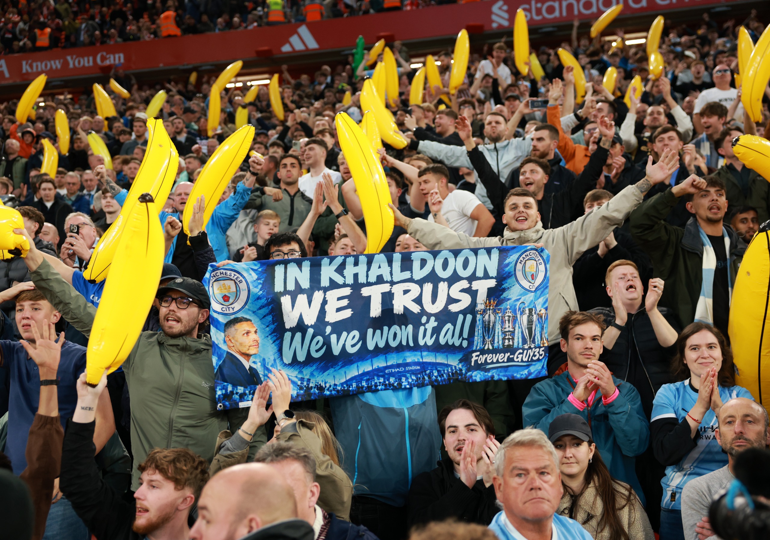 Manchester City fans hold up inflatable bananas and a banner that reads "In Khaldoon we trust"