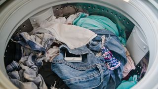 What should and shouldn't go in the washing machine: An image showing a white phone left in a pair of jeans in the washing machine