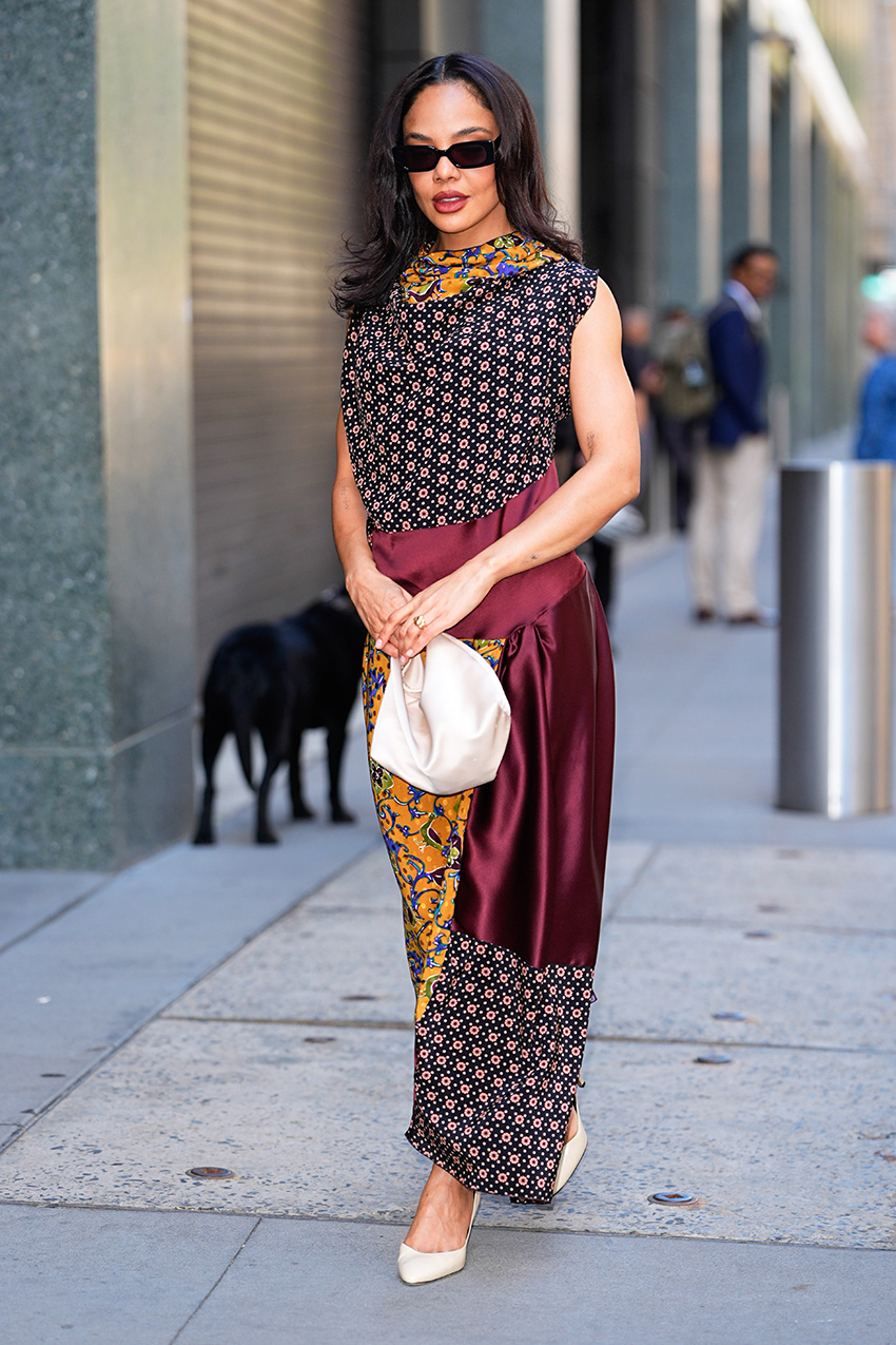 Tessa Thompson wearing a scarf-print dress with a cream satin handbag and cream leather pumps
