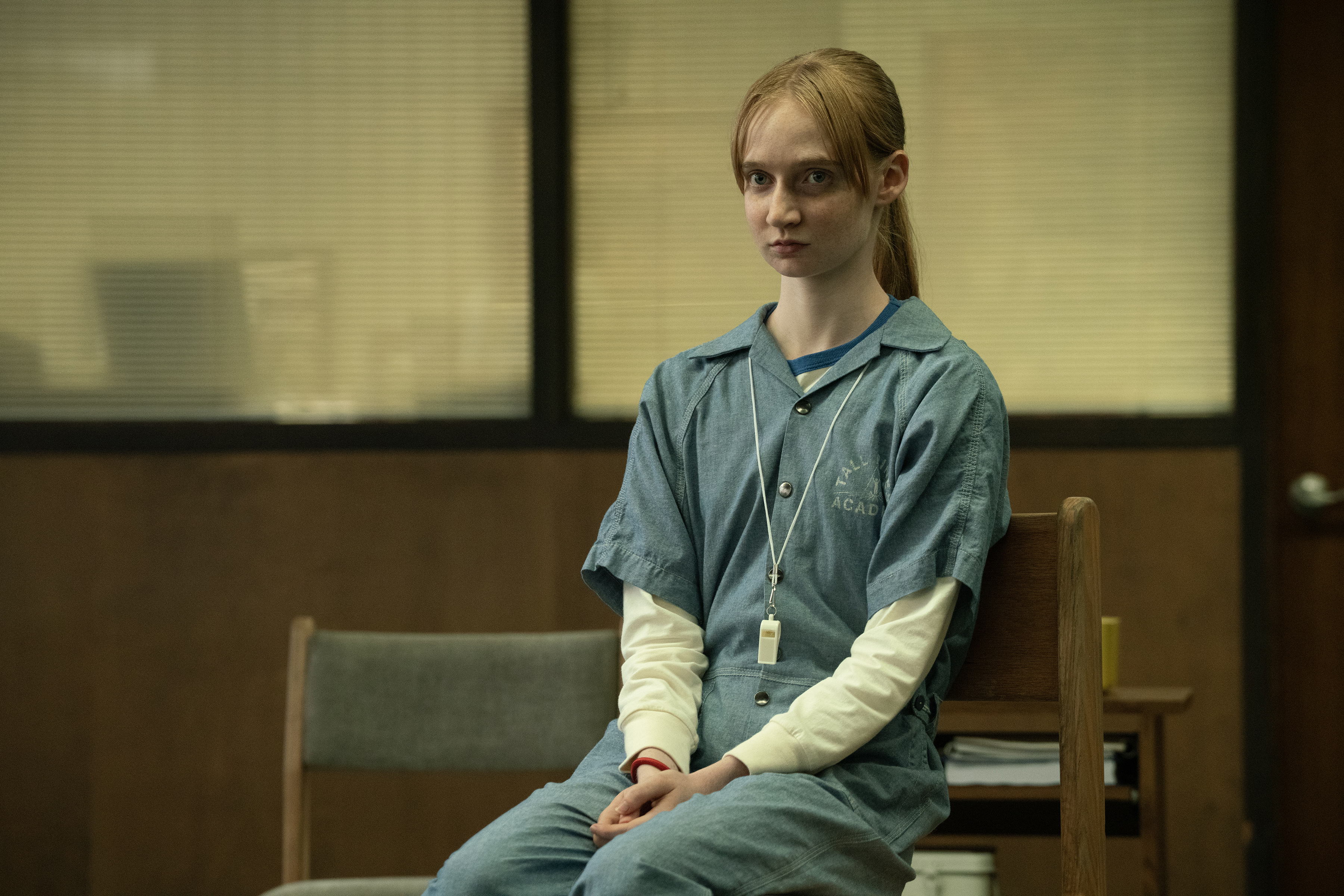 Isolde Ardies as Stacey wearing a blue jump suit in group therapy in wayward